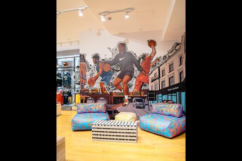 Brightly coloured mural on wall of Foot Locker Brixton depicting three basketball players, with two chairs in front of it